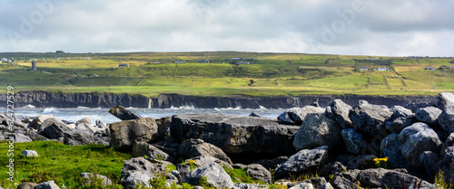 Scogliera irlandese sullo fondo vita da una spiaggia delimitata da grossi scogli (Irlanda, Doolin) photo