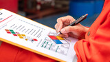 A safety engineer is using pen to rating the health risk assessment level of chemical hazardous material in the paperwork form. Industrial safety working scene, close-up and selecitve focus.