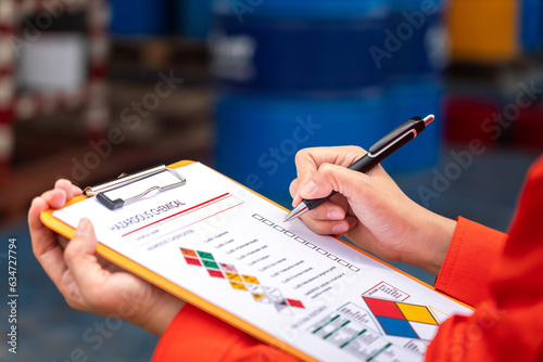Obraz na plátně A safety engineer is using pen to rating the health risk assessment level of chemical hazardous material in the paperwork form