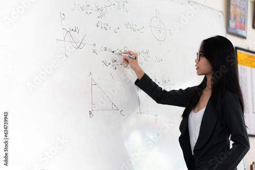 asian teacher write on white board. Woman writing on white board wall. Idea creative education teaching math and spelling letter, knowledge, back to school concept