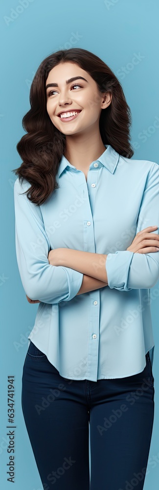 Casually dressed woman on blue background smiling and presenting blank copy space Casually dressed woman on blue background smiling and presenting blank copy space