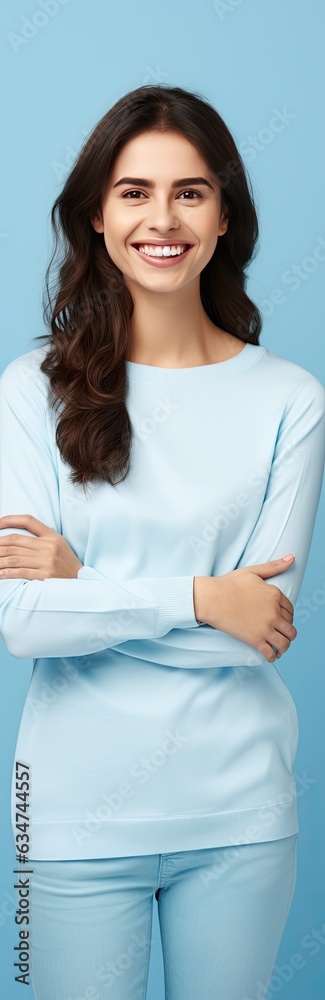 Casually dressed woman on blue background smiling and presenting blank copy space Casually dressed woman on blue background smiling and presenting blank copy space