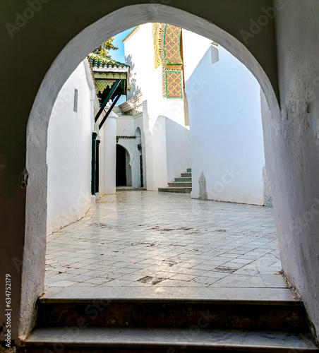 Entrance door and stairs with arches and green tiles, old tiles and eb ceramics in the Andalusian mosaic style at the Beb Sidi Boumediene mosque in Tlemcen, Algeria. HDR dark foreground and sunny day. photo
