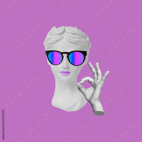 Confident antique female statue's head in colorful sunglasses shows the ok gesture with hand isolated on a purple color background. Trendy collage in magazine style. 3d contemporary art. Modern design