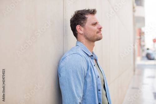handsome man on profile view looking to copy space ahead, thinking, imagining or daydreaming