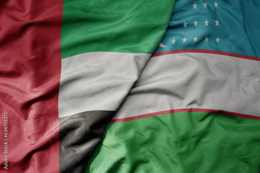big waving realistic national colorful flag of united arab emirates and national flag of uzbekistan .