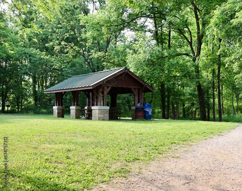 The wood picnic shelter in the park on a sunny day.