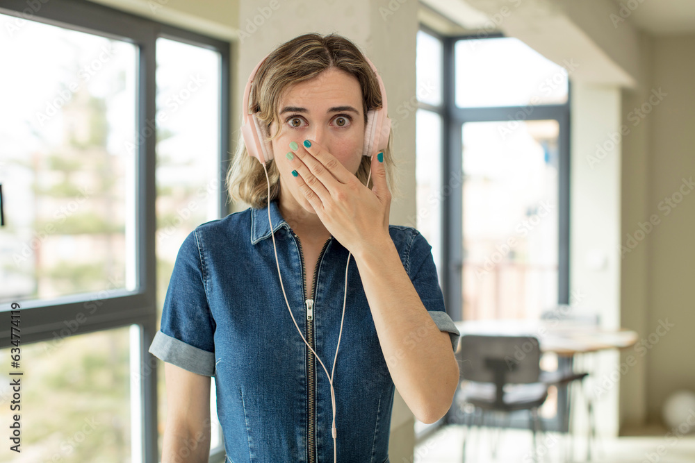 pretty woman covering mouth with a hand and shocked or surprised expression. headphones and music concept pretty woman covering mouth with a hand and shocked or surprised expression. headphones and music concept