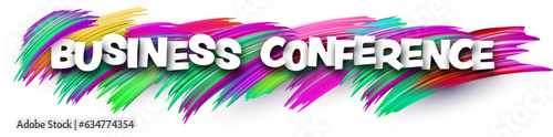 Business conference paper word sign with colorful spectrum paint brush strokes over white.