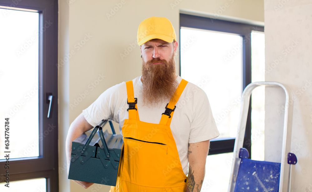 red hair man feeling sad and whiney with an unhappy look and crying repairing home. handyman concept red hair man feeling sad and whiney with an unhappy look and crying repairing home. handyman concept