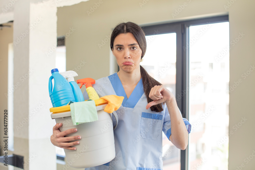 pretty young model feeling cross,showing thumbs down. housekeeper concept pretty young model feeling cross,showing thumbs down. housekeeper concept