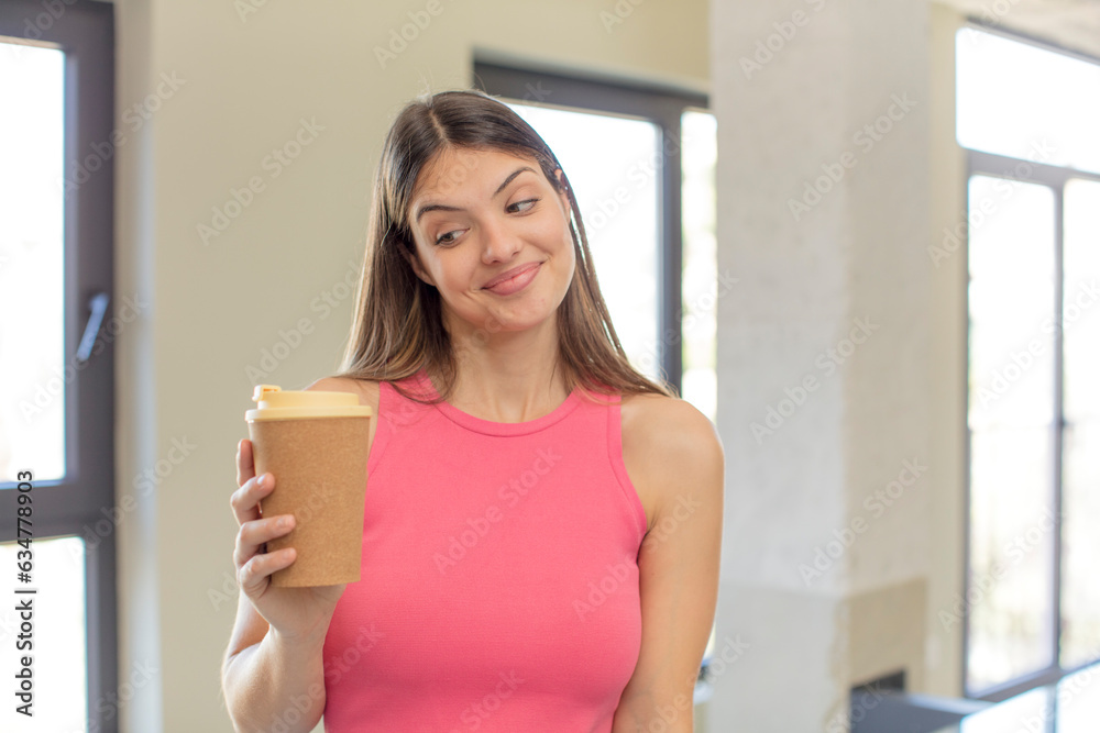 young pretty woman smiling and looking with a happy confident expression. take away coffee concept young pretty woman smiling and looking with a happy confident expression. take away coffee concept