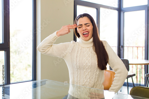 pretty caucasian woman looking unhappy and stressed, suicide gesture making gun sign with hand, pointing to head Free Download pretty caucasian woman looking unhappy and stressed, suicide gesture making gun sign with hand, pointing to head - GFXLoad