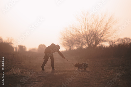 Niño paseando con su perro durante el atardecer