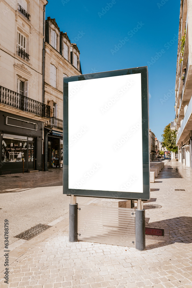 Fototapeta premium Mockup d'affiche en ville - 120 x 176 - sucette - mock up de poster en bord de route de zone urbaine - journée ensoleillée - incrustation de pub