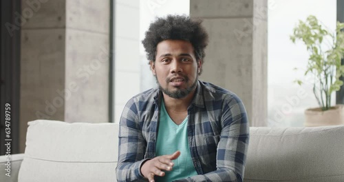 Young black man blogger talks speaks. Man speaks, gesticulates, explaining, talking. Black man teacher coach blogger offers online lessons. Multiethnic broadcaster shares his thoughts via webcam.
