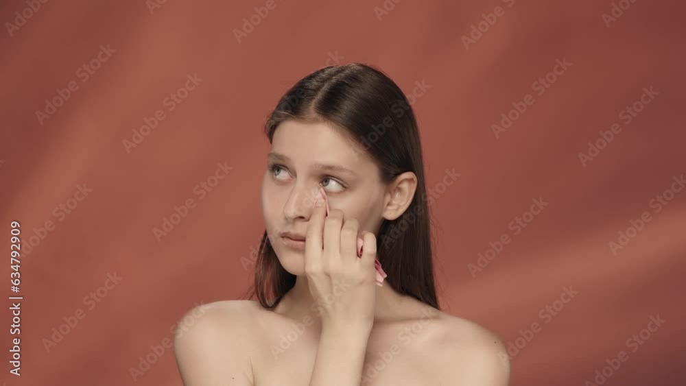 Sad expression. Woman crying, wiping tears away with a tissue. Depression, anxiety, distress. Seminude sad woman in the studio on a red background. Sad expression. Woman crying, wiping tears away with a tissue. Depression, anxiety, distress. Seminude sad woman in the studio on a red background.