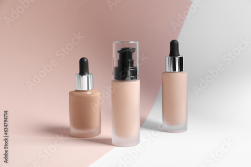 Bottles of skin foundation on color background. Makeup product