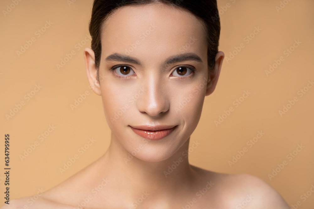 Young asian woman with naked shoulders looking at camera isolated on beige Young asian woman with naked shoulders looking at camera isolated on beige