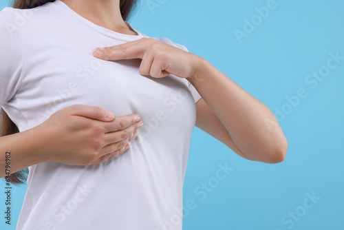 Wallpaper Mural Woman doing breast self-examination on light blue background, closeup Torontodigital.ca