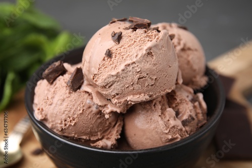 Bowl with tasty chocolate ice cream on blurred background, closeup