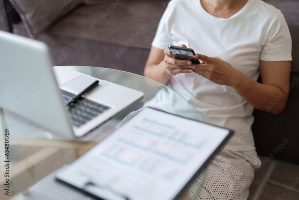 Happy young woman sitting at the living room working from home.