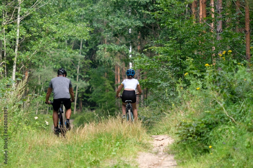 Fototapeta premium Man and his daughter on bicycle in forest