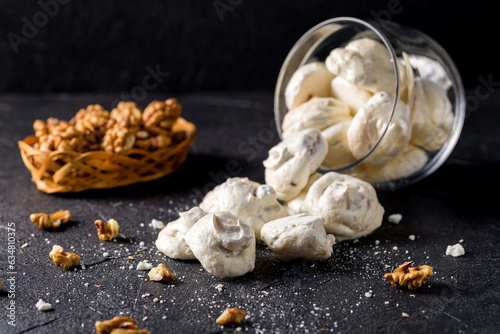 Small white meringues on a dark background