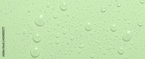 Drops of micellar water or cosmetic tonic on a green background. Close-up, macro photography photo