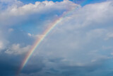Beautiful rainbow in the blue sky, white clouds