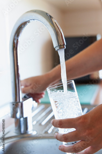 Woman filling a glass of water at the faucet