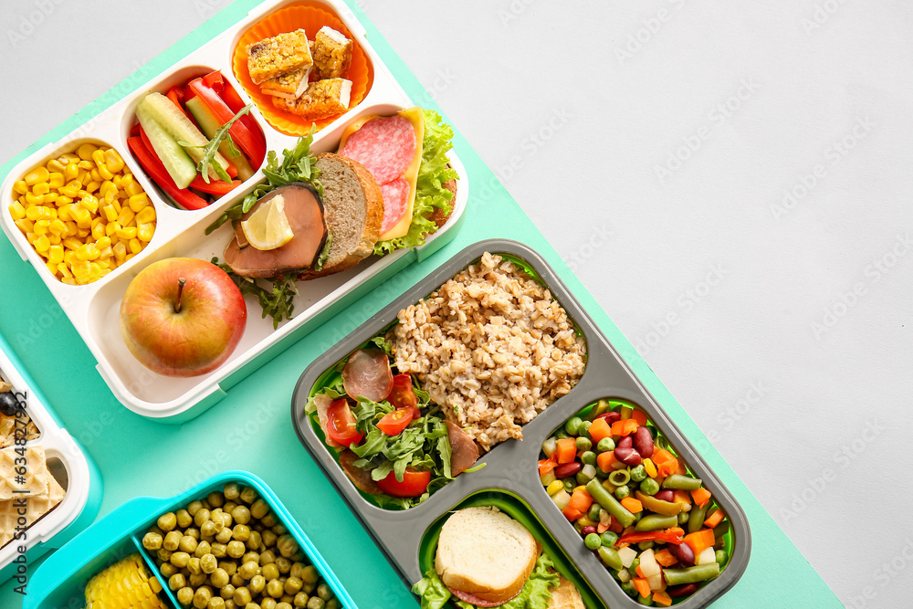Lunchboxes with different delicious food on color background Lunchboxes with different delicious food on color background
