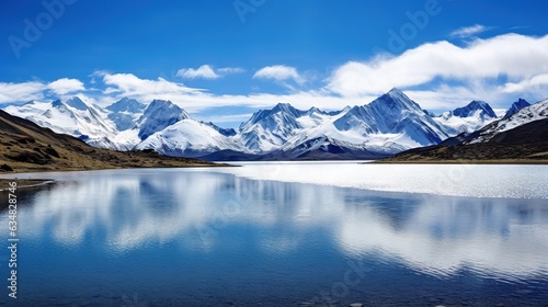  a lake surrounded by mountains under a blue sky with clouds.  generative ai © Anna