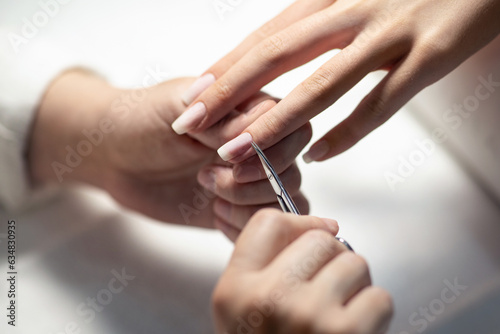 Fotografia Nail Technician Making Manicure Cutting Cuticle At Beauty Salon, Closeup
