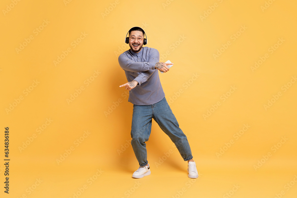 Full Length Shot Of Cheerful Young Asian Man Dancing On Yellow Background Full Length Shot Of Cheerful Young Asian Man Dancing On Yellow Background