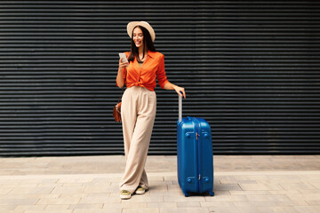 Joyful Traveler Woman Using Phone Application to Book Ticket Outside