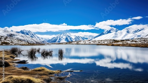  a lake surrounded by snow covered mountains under a blue sky. generative ai