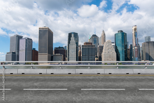Empty urban asphalt road exterior with city buildings background. New modern highway concrete construction. Concept of way to success. Transportation logistic industry fast delivery. New York. USA.