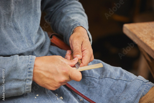 Guy carving wood at viking festival in Denmark. Close-up