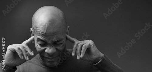 deaf man suffering from deafness and hearing loss on grey background with people stock image stock photo