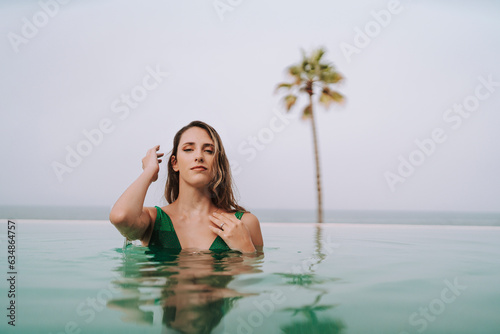 Chica delgada con pelo largo posando en una piscina de un hotel paradisiaco  © MiguelAngelJunquera