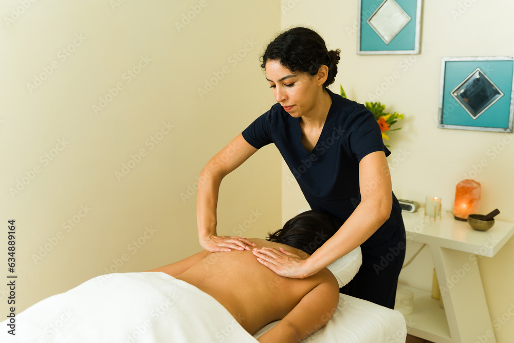 Tired woman at the wellness spa getting a back massage Tired woman at the wellness spa getting a back massage