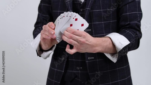 A card magician, a croupier in a casino, smoothly shows a deck of cards. Game card tricks.