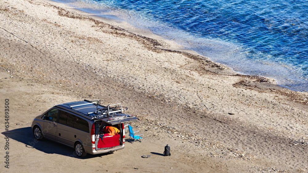 Van with camp equipment on beach. Aerial view Van with camp equipment on beach. Aerial view