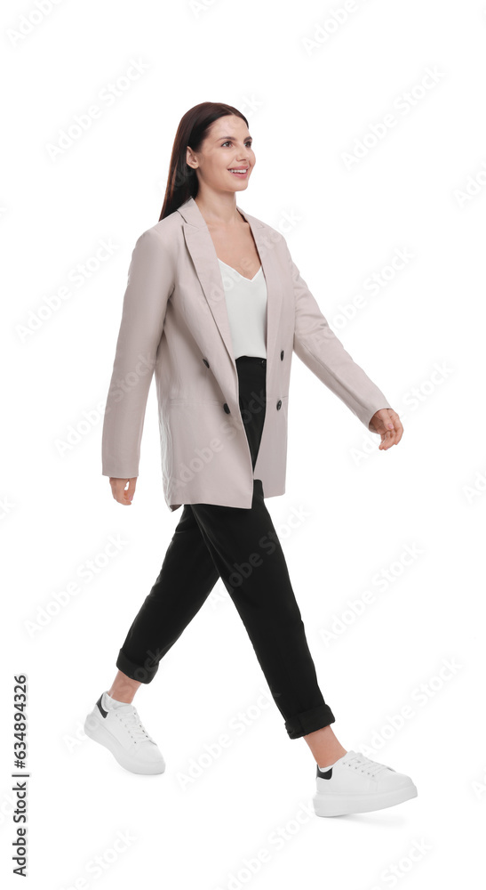 Beautiful businesswoman in suit with laptop walking on white background Beautiful businesswoman in suit with laptop walking on white background
