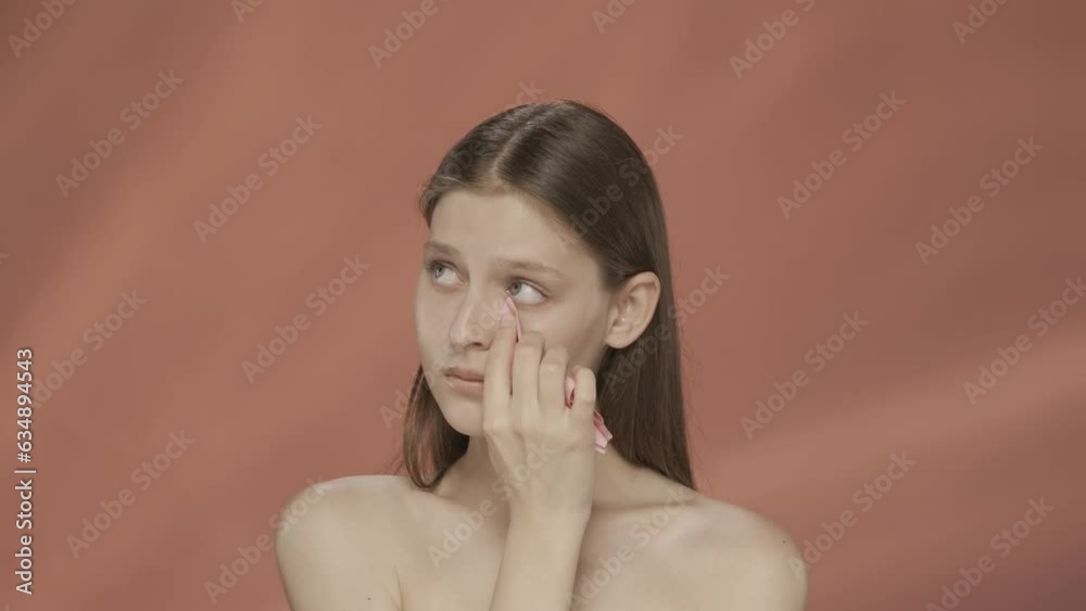 Sad expression. Woman crying, wiping tears away with a tissue. Depression, anxiety, distress. Seminude sad woman in the studio on a red background. HDR BT2020 HLG Material. Sad expression. Woman crying, wiping tears away with a tissue. Depression, anxiety, distress. Seminude sad woman in the studio on a red background. HDR BT2020 HLG Material.