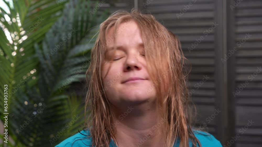 Portrait of tired woman with wet hair near palm tree, examines her hairstyle, sighs. Humid tropical climate Problem of damaged, dry hair Recovery, care Frustrated client touching curl with split ends Portrait of tired woman with wet hair near palm tree, examines her hairstyle, sighs. Humid tropical climate Problem of damaged, dry hair Recovery, care Frustrated client touching curl with split ends