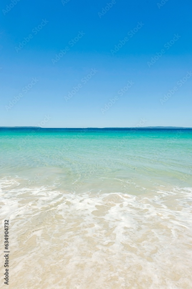 Clear turquoise waters, cloudless blue skies, sea foam and white sand on a sunny day at Callala Beach in Shoalhaven — Jervis Bay National Park, New South Wales, Australia