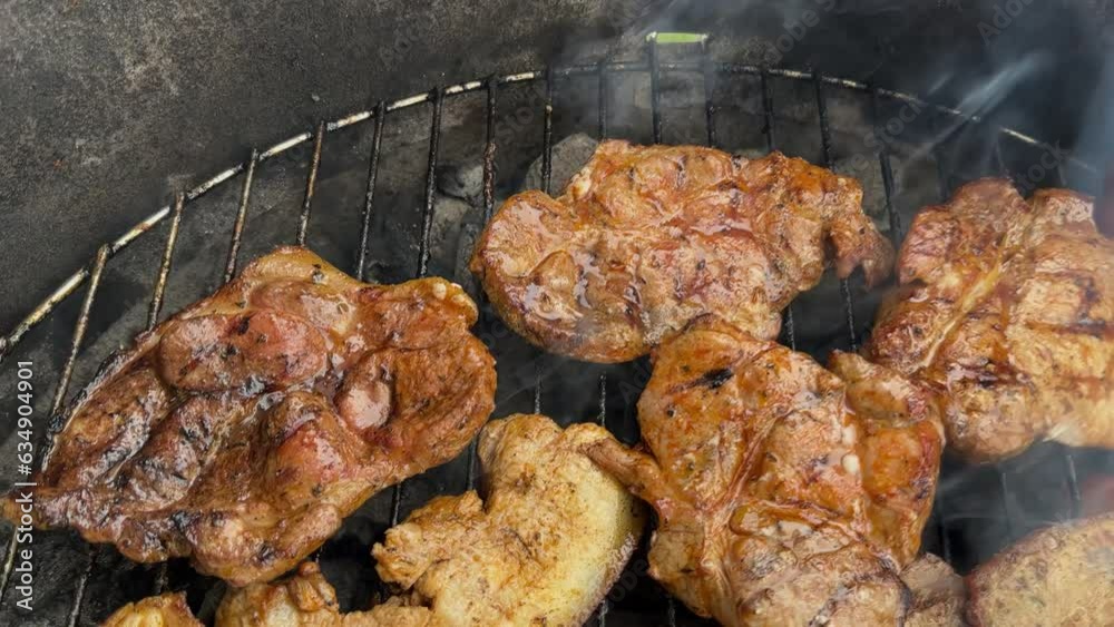 Juicy Pork Belly and Marinated Pork Steaks on the Grate of an Open Charcoal Grill Juicy Pork Belly and Marinated Pork Steaks on the Grate of an Open Charcoal Grill