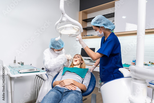 Female dentist examine tooth to Caucasian girl at dental health clinic.  photo